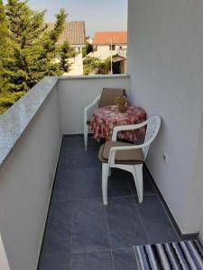 un tavolo e sedie su un balcone con tavolo di Apartment Jasmina - with balcony and free parking a Nin