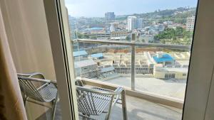 a balcony with two chairs and a view of a city at Nagoya thamrin apartment (Favehotel Building) in Nagoya