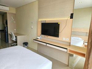 Habitación de hotel con cama y TV de pantalla plana. en Nagoya thamrin apartment (Favehotel Building), en Nagoya