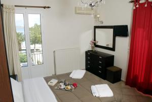 a bedroom with a bed and a dresser and a mirror at Pension Hirolakas in Galaxidi