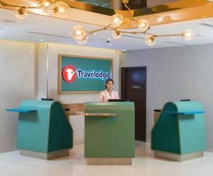 a woman is standing at a counter in a lobby at Travelodge Bukit Bintang in Kuala Lumpur