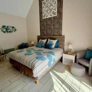 a bedroom with a large bed with blue pillows at Le balcon des cimes in Adast