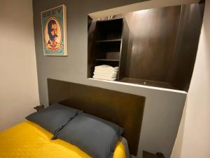 Cama en habitación con estantería y almohada amarilla en Cozy Condesa, en Ciudad de México