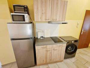 eine Küche mit einem Kühlschrank aus Edelstahl und einer Mikrowelle in der Unterkunft cozy Apartments in Mülheim in Köln
