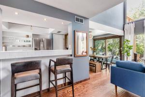 een keuken en een woonkamer met een blauwe bank en stoelen bij 3b2b Hidden Oasis in the Hills-Close to Downtown in Austin