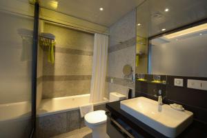 a bathroom with a sink and a toilet and a tub at Hotel Madera Hong Kong in Hong Kong