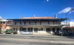 un bâtiment avec des voitures garées devant lui dans l'établissement Royal Hotel, à Tumut