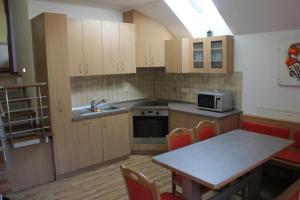 a kitchen with wooden cabinets and a table with chairs at Charming countryside house in Lome