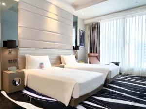 a hotel room with two beds and a large window at Hotel Madera Hong Kong in Hong Kong