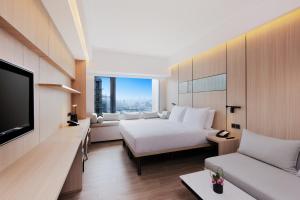 Habitación de hotel con cama y TV en Metropolitan Residence en Shanghái