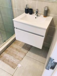 a bathroom with a white sink and a shower at Luxury beach lagoon 1 Bedroom apartment in Pretoria