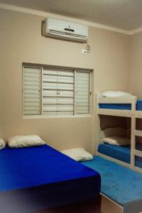 a bedroom with two bunk beds and a fan at Chacara Las Palomas in Presidente Epitácio