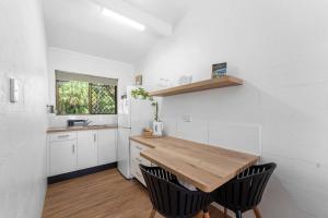 a kitchen with a wooden table and black chairs at Kinka Palms Motel in Kinka