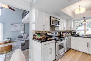a kitchen with white cabinets and a living room at 2b1b Hidden Oasis in the Hills- Close to Downtown in Austin