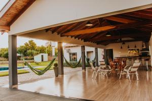 a patio with a hammock and a table and chairs at Chacara Las Palomas in Presidente Epitácio