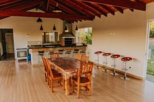 a kitchen and dining room with a wooden table and chairs at Chacara Las Palomas in Presidente Epitácio