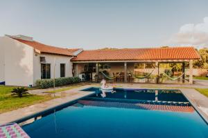 a villa with a swimming pool in front of a house at Chacara Las Palomas in Presidente Epitácio