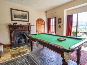 a living room with a pool table and a fireplace at The Stables in Ambleside