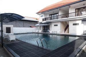 a swimming pool in front of a house at Hippo Diving Bali Rooms in Sanur