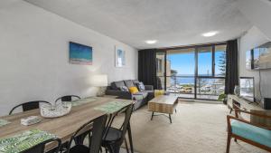 sala de estar con mesa de comedor y sofá en Beachpark Apartments - Close To Beach en Port Macquarie