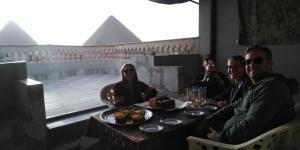 a group of people sitting at a table with food at Queen Pyramids View Inn in Cairo