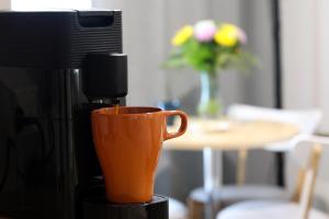 an orange cup sitting on top of a coffee maker at Nebula Motel in Cooma