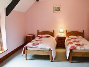 Loders的住宿－The Retreat，卧室设有两张单人床和粉红色的墙壁