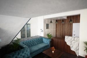 ein Wohnzimmer mit einem blauen Sofa in einem Zimmer in der Unterkunft Castle Suites by Haven Homes, Kempegowda International Airport road in Bangalore