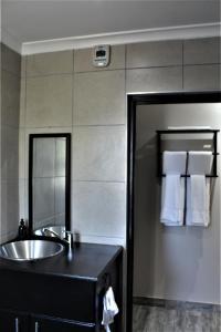 une salle de bain avec un lavabo et un miroir dans l'établissement 9 Serendipity Stay, à George 31 autres photos