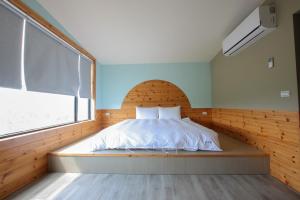 a bed in a room with a large window at 峰樹屋 in Hengchun