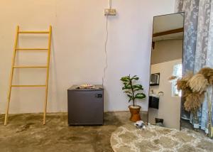 a room with a small refrigerator and a mirror at A Little Bit Guesthouse in Melaka