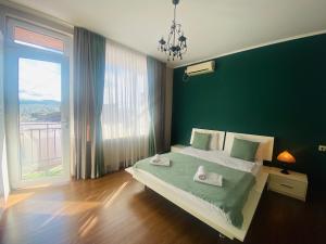 um quarto com uma cama grande e uma parede verde em 9 Borbalo Street Apartment with terrace em Tbilisi