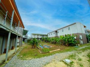 Un edificio con muchas plantas en el frente. en House&Cafe GreenTerrace, en Ishigaki Island