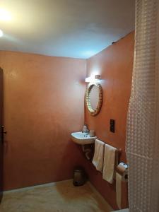 a bathroom with a sink and a mirror at kasbah Dar Bahnini in Skoura