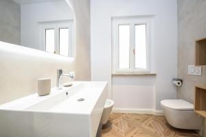 bagno bianco con lavandino e servizi igienici di Madalì Suite & Apartments Brescia a Brescia