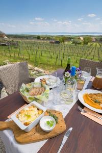 einen Tisch mit Lebensmitteln und Blick auf einen Weinberg in der Unterkunft Tagyon Birtok Royal Apartmanház in Tagyon