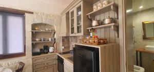 een kleine keuken met een zwarte koelkast en planken bij Aelia Apartment III in Kamilari
