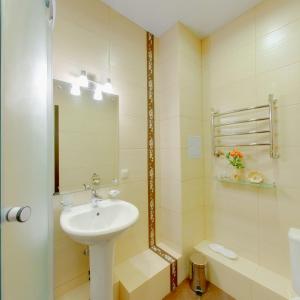 a white bathroom with a sink and a mirror at Parus Hotel in Korolyov