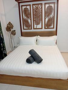 Una cama con una toalla negra puesta. en The Beach House @ Kuantan, en Kuantan