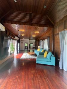 a living room with a blue couch in a room at Genesis villa- front beach peaceful villa big infinity swimming pool in Amphoe Koh Samui