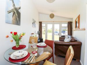 a dining room with a table and a living room at Chalet 150 in Great Yarmouth +13 photos