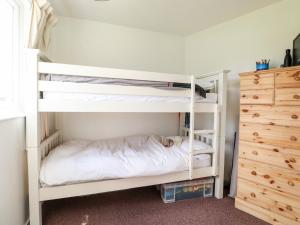 a bedroom with two bunk beds and a dresser at Chalet 150 in Great Yarmouth