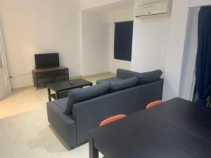 un soggiorno con divano blu e tavolo di Apartamento cinta 3 habitaciones a Siviglia