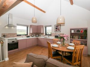a kitchen and dining room with a table and chairs at Sevenwoods View in Longhope