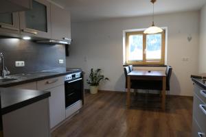 una cucina con un tavolo, una stufa e un lavandino di Appartement Nummer 12 a Going 1 altra foto