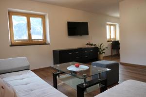 un soggiorno con un tavolo e una TV di Appartement Nummer 12 a Going
