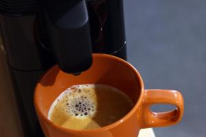 an orange cup of coffee is being brewed at Nebula Motel in Cooma