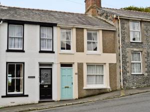 a house with a blue door on a street at Castle Street in Llanystumdwy