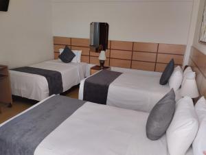 Habitación de hotel con 2 camas y TV en Xima Central Tacna, en Tacna