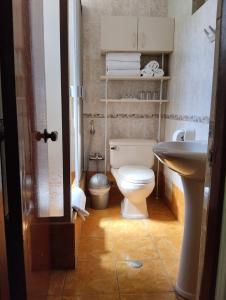 a bathroom with a white toilet and a sink at Xima Central Tacna in Tacna